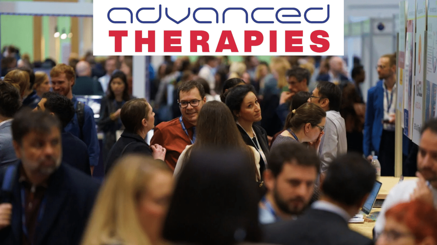 A crowd of people interact at a conference under a sign reading advanced THERAPIES in blue and red text.