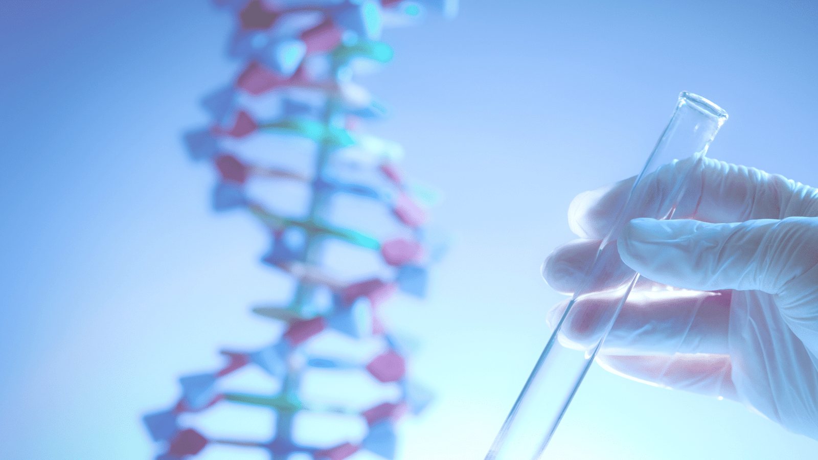 A gloved hand holds a test tube in the foreground, with a blurred model of a DNA double helix in the background, both lit by a cool blue light.